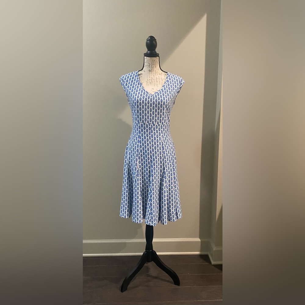 Fitted v-neck dress has a bottom flare. It hits just below the knee.